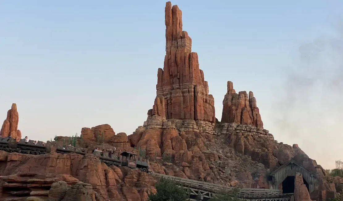 Vía del tren de la montaña rusa Indiana Jones and the Temple of Peril rodeada de vegetación.
