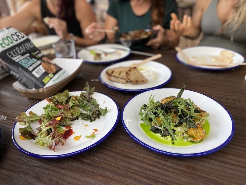 Mesa servida con platos de ensaladas orgánicos cultivados en Juntos Farm en Ibiza.