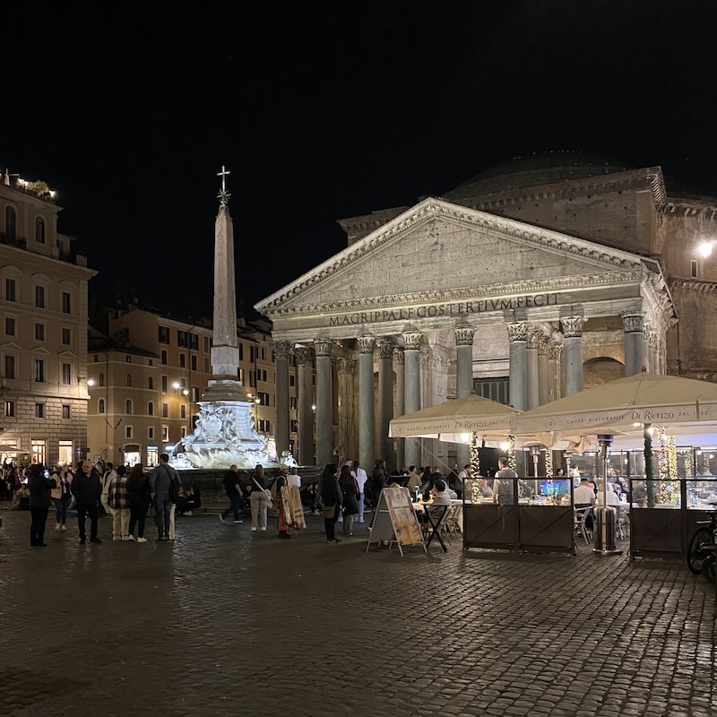 Fachada iluminada del Panteón de Agripa de noche en una plaza de Roma sin multitudes.