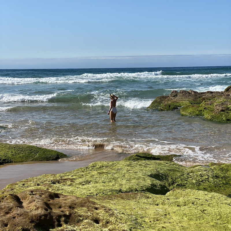Persona entrando al mar en la playa de Liencres, un arenal salvaje en Cantabria