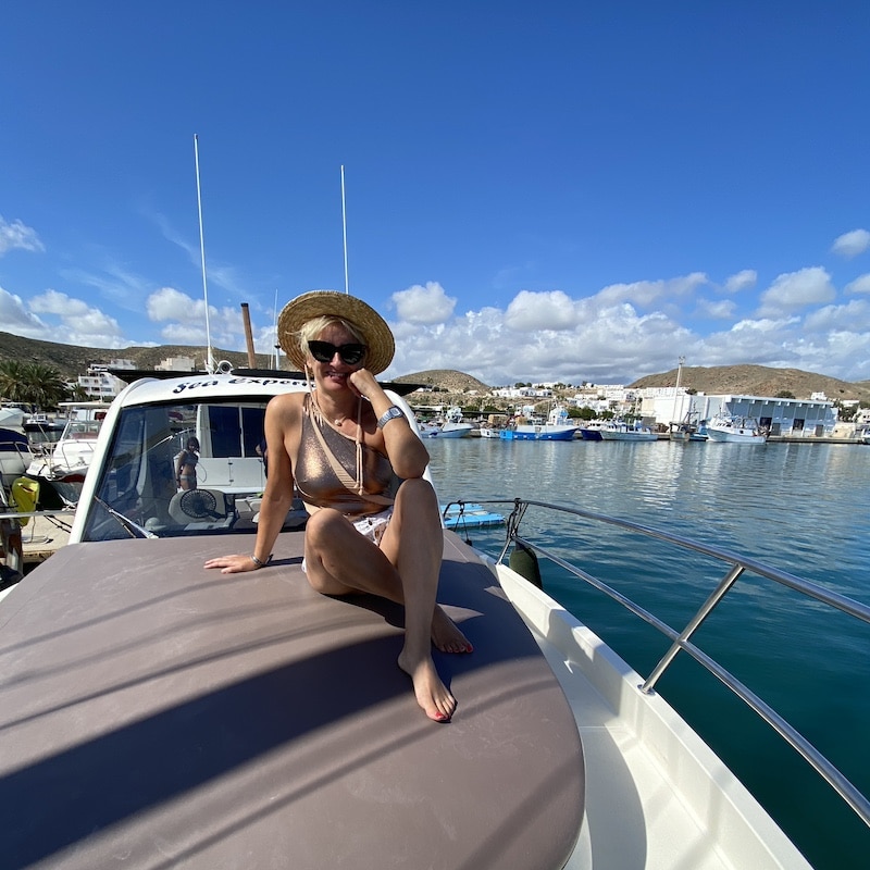 Mónica de El Viaje de Sofi sentada en la cubierta de un yate en el puerto de Carboneras antes de hacer una excursión hasta Cala de Enmedio.