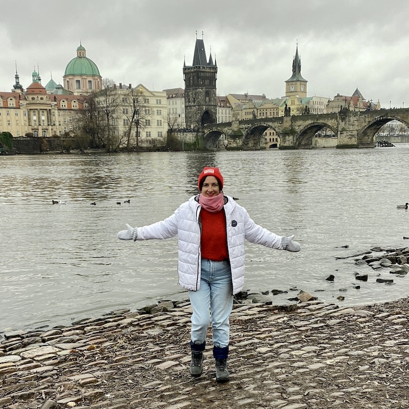 en Praga vestida por capas para el invierno, mostrando ropa termica, abrigo y bufanda durante una escapada de Navidad.
