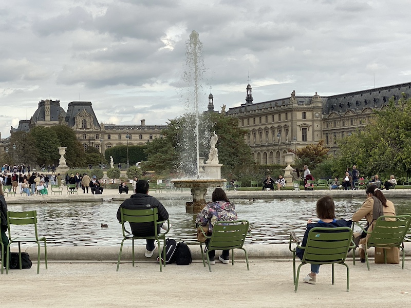 Personas descansando frente a una fuente en los Jardines de las Tullerías en París