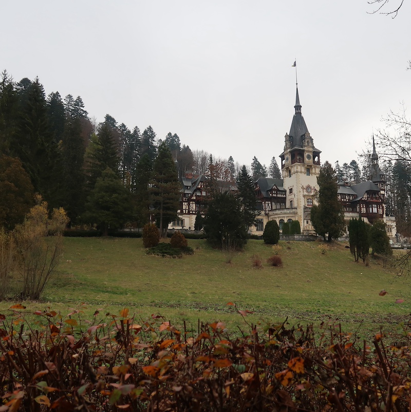 Fachada exterior del Castillo de Peles en Sinaia rodeado de la naturaleza de los Cárpatos en Rumanía.