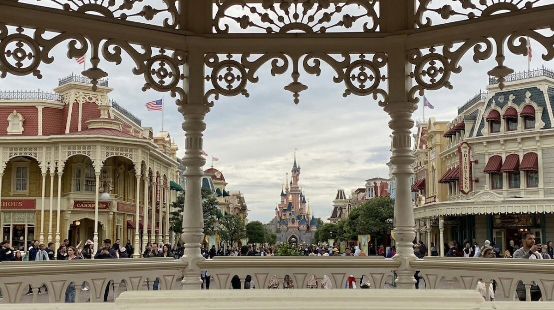 Vista panorámica de Main Street U.S.A. y el Castillo de la Bella Durmiente en Disneyland Paris desde el mirador de la estación en un día nublado.