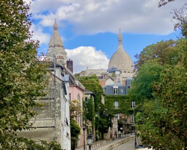 Calle empedrada de Montmartre con artistas y fachadas pintorescas