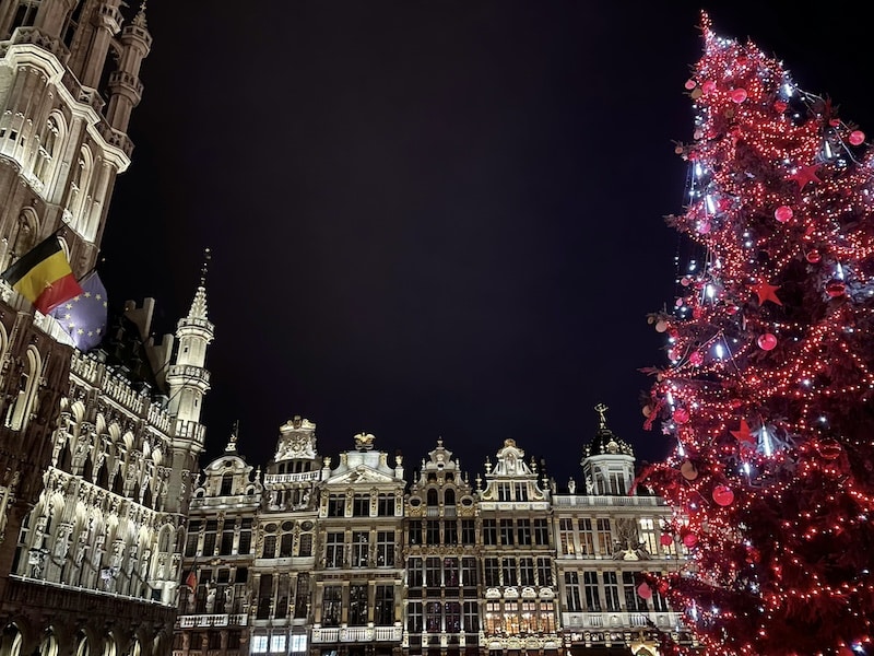 Grand-Place de Bruselas iluminada por la noche durante Navidad, con árbol gigante y decoración luminosa