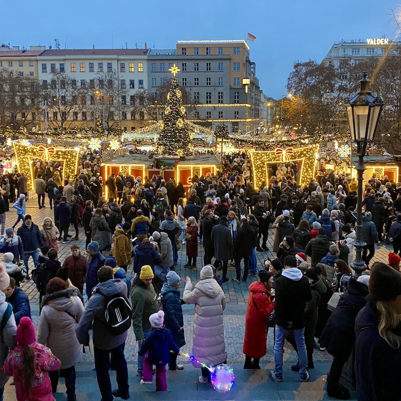 Mercado navideño de Náměstí Míru en Praga con puestos de comida, luces y ambiente local.
