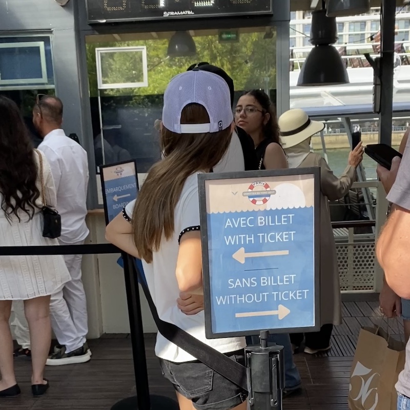 Cartel en el muelle de París indicando las filas para personas con y sin billete.