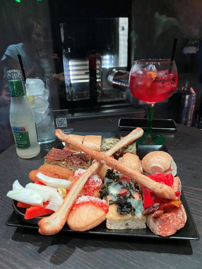 Aperitivo italiano con Aperol Spritz y tablas de embutidos en un wine bar del barrio de Chiaia en Nápoles