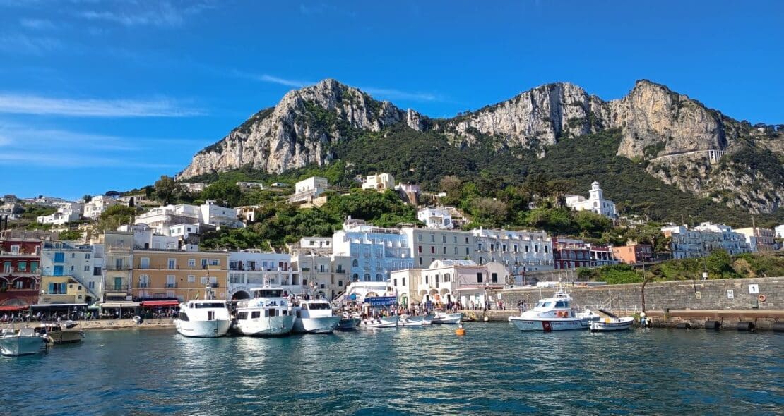 Puerto de Marina Grande en Capri con barcos atracados y casas de colores bajo la montaña
