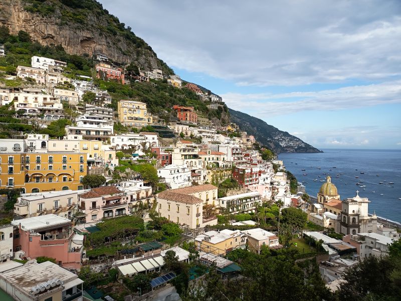 Paisaje típico de la Costa Amalfitana con la cúpula de mayólica de Positano y el mar Tirreno.