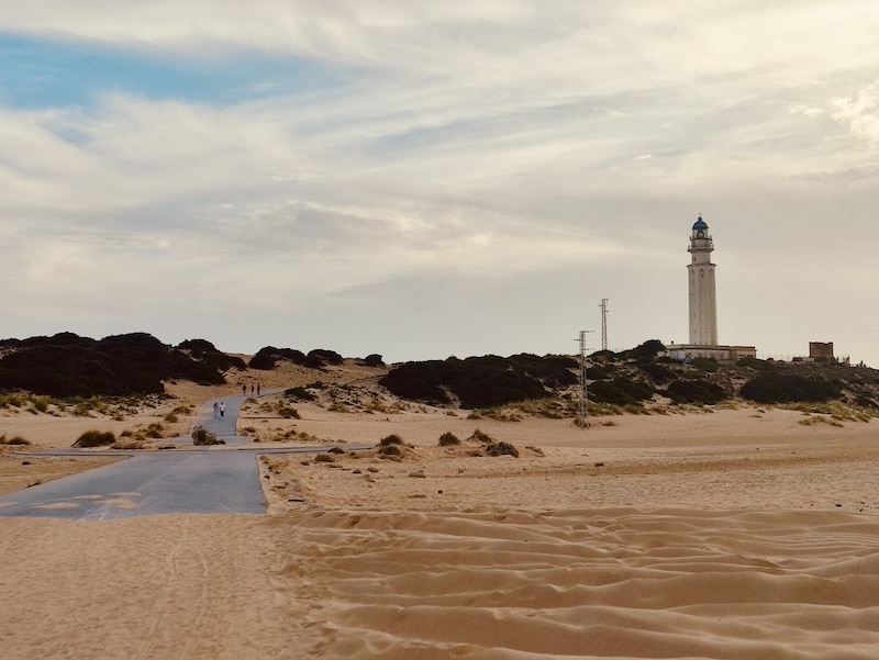 Faro de Trafalgar en Los Caños de Meca durante un atardecer con tonos dorados sobre la arena
