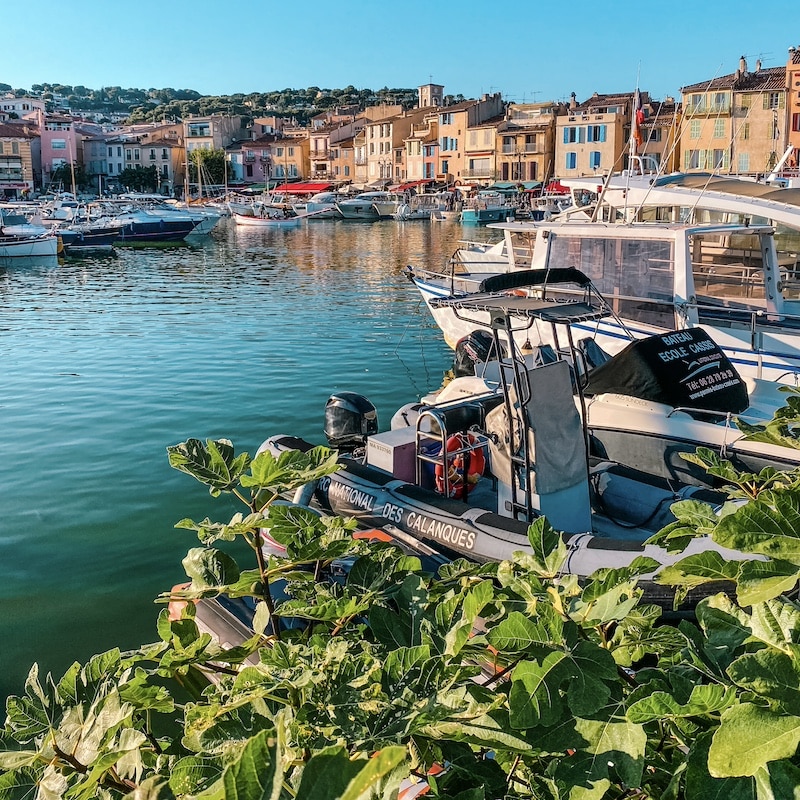 Vista panorámica del puerto de Cassis con barcos de pesca y fachadas de colores al sol.