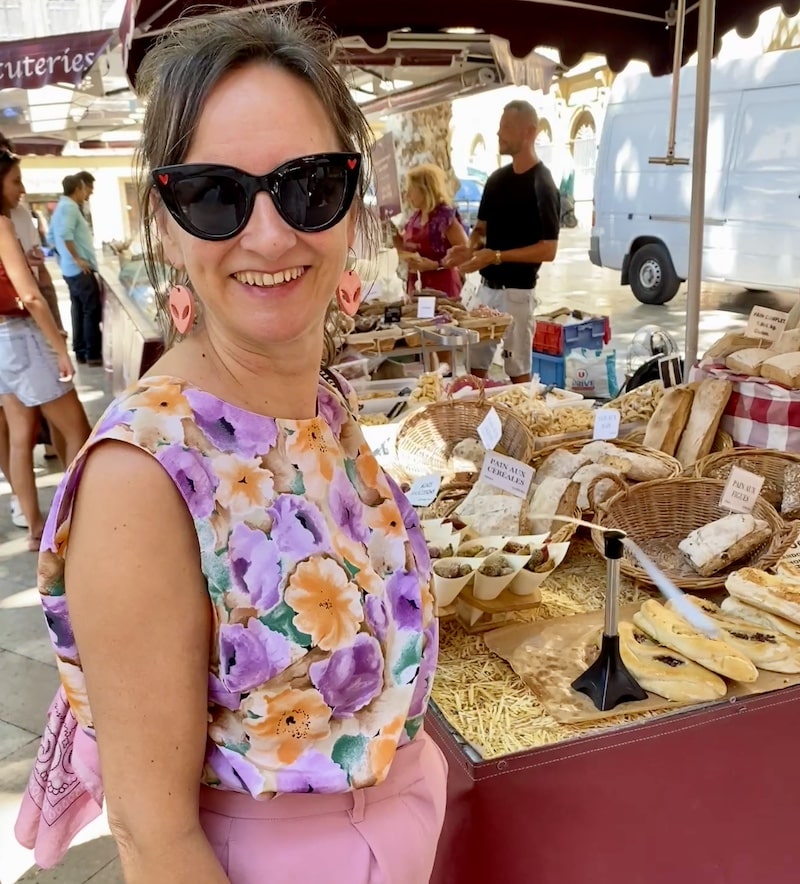 Mónica (el Viaje de Sofi) entre los puestos de frutas y verduras frescas en el mercado local de Aix-en-Provence.