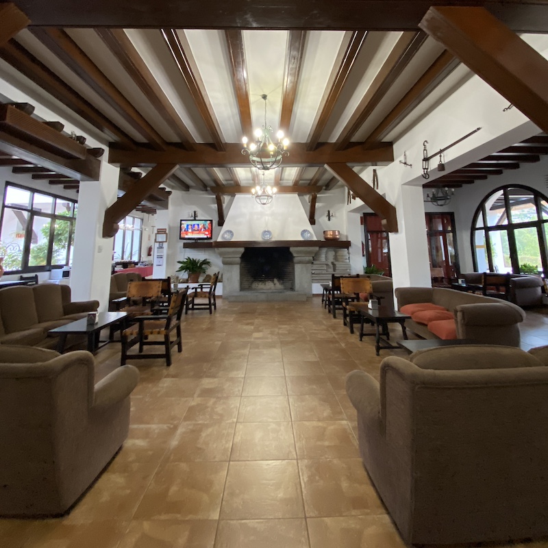 Salón rústico y acogedor con chimenea en el hotel Tugasa Las Truchas en El Bosque, Sierra de Cádiz.