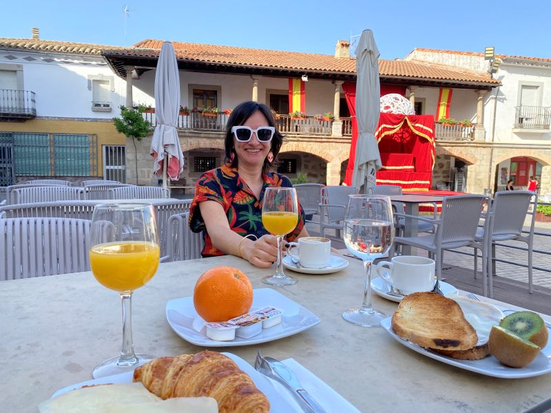 Mónica desayunando zumo de naranja y croissants en una terraza de la Plaza Mayor de Dos Torres Córdoba