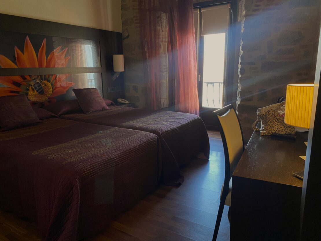 Habitación de hotel rural con paredes de piedra y vigas de madera en la comarca de Los Pedroches