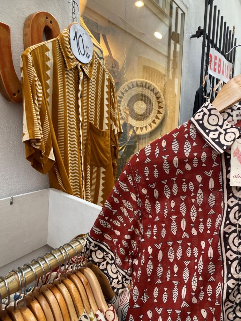 Camisas estampadas de estilo surfero y boho colgadas en un perchero de una tienda local en Tarifa