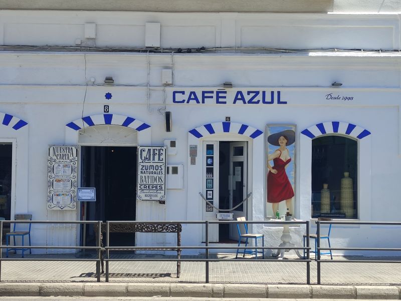 Fachada blanca y azul del icónico Café Azul en Tarifa, famoso por sus desayunos.
