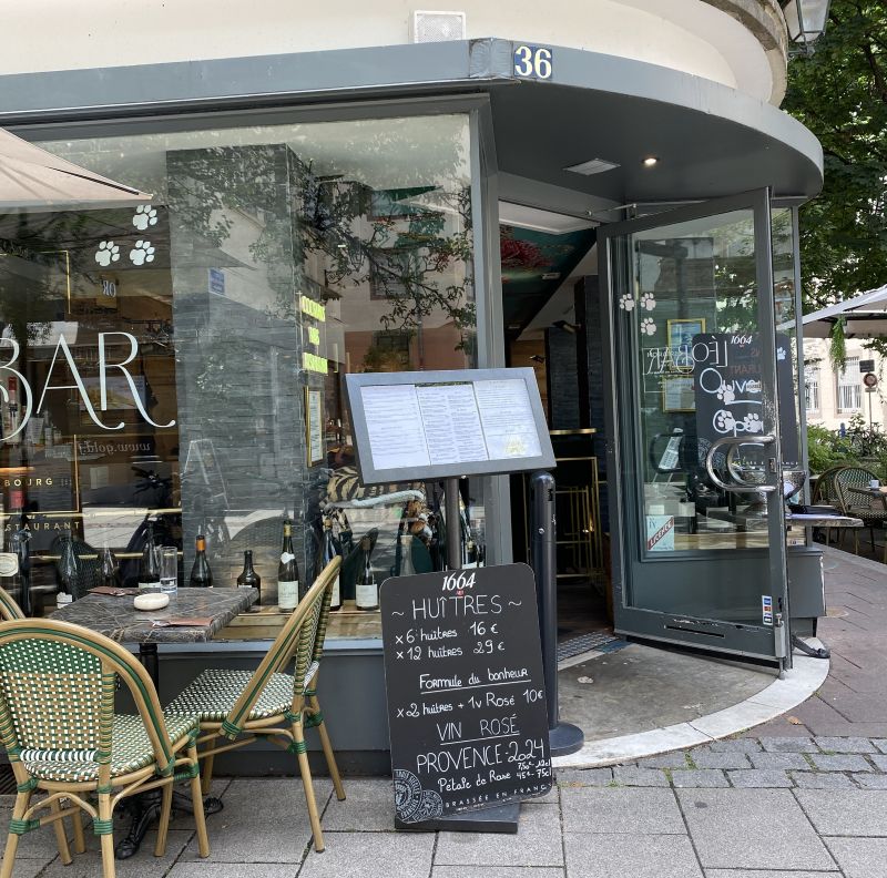 Terraza de una brasserie tradicional con carteles de menú para comer en Alsacia