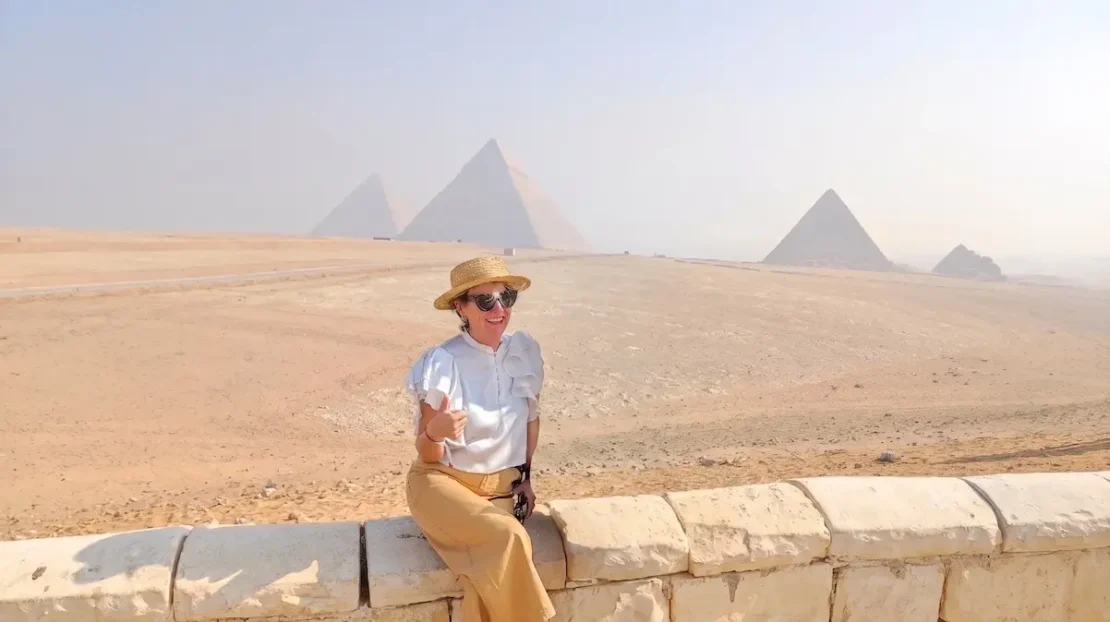 Mónica con sombrero de paja sonriendo en el mirador de las Pirámides de Giza durante un viaje a Egipto organizado