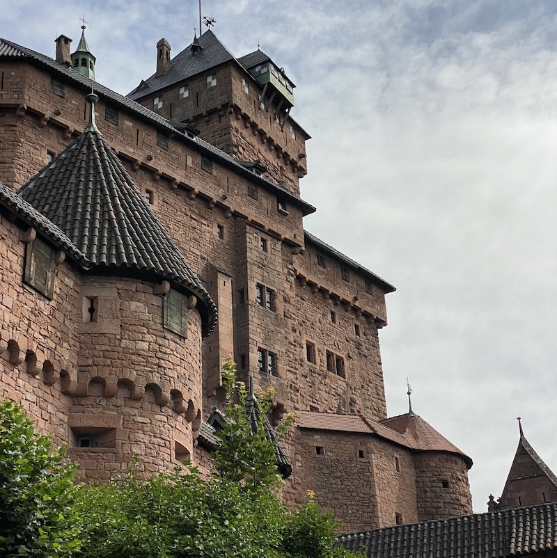 Torres de piedra rosada y muralla del Castillo de Haut-Koenigsbourg visto desde la entrada inferior