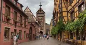 Calle empedrada Rue du General de Gaulle en Riquewihr con casas de colores y la Torre Dolder