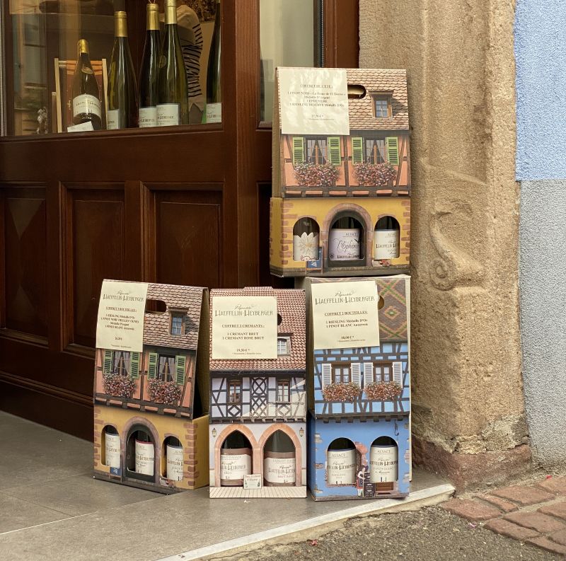 Cajas de vino decoradas y botellas en una bodega de Eguisheim